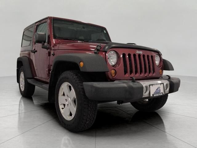 2012 Jeep Wrangler 4WD 2dr Sahara in Deep Cherry Red Crystal Pearl — front three-quarter view
